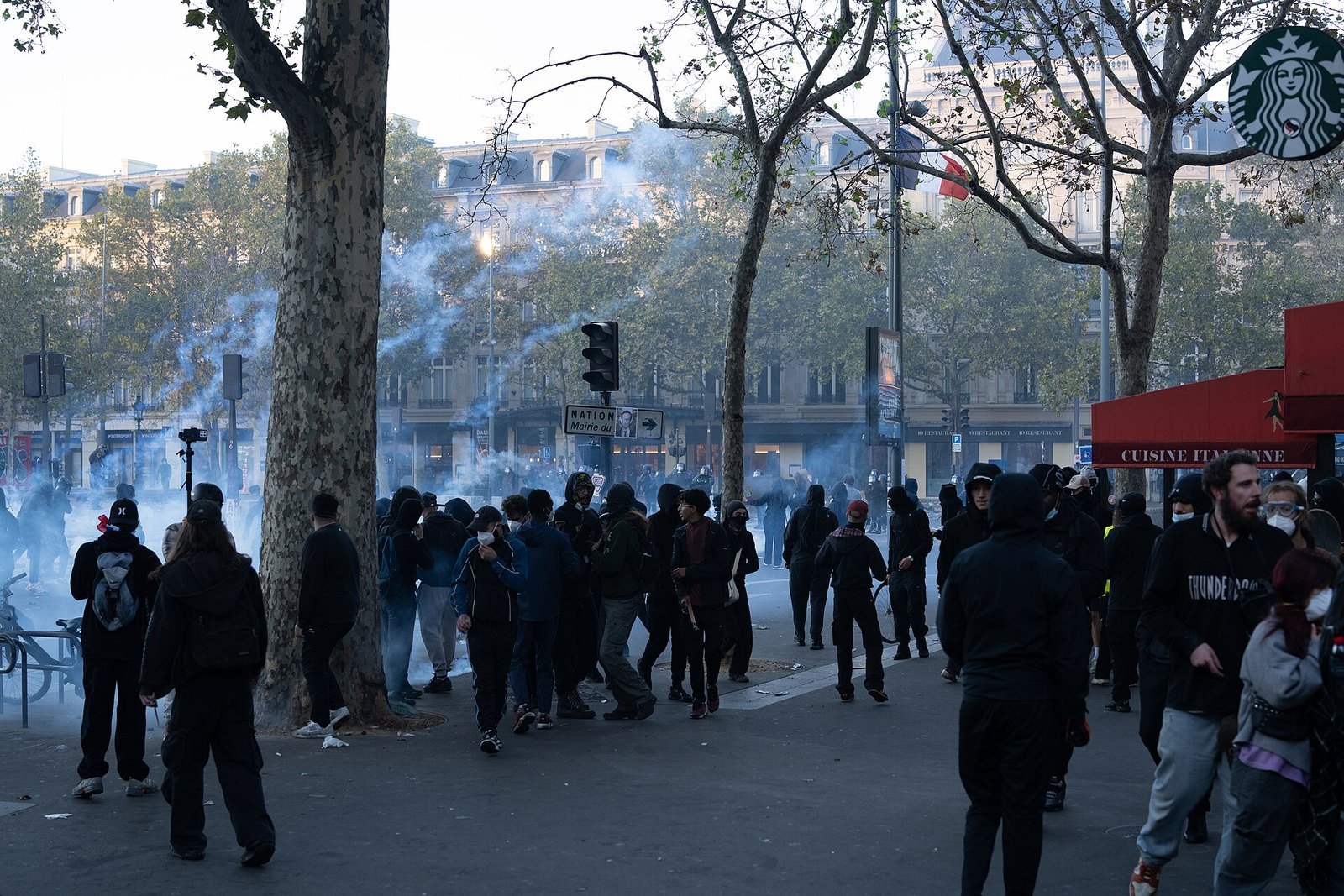 Tear gas drifts over Place de la République in Paris on 17 October 2026. <em>Pho”/><figcaption>Tear gas drifts over Place de la République in Paris on 17 October 2026. <em>Photo: Jorge Jaramillo, CC BY-SA 4.0, via <a href=